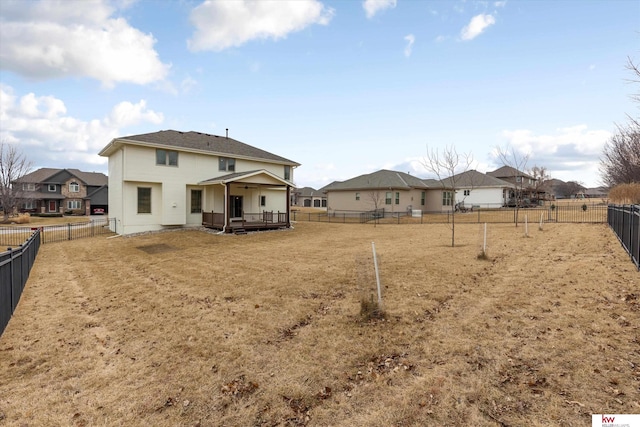 rear view of house featuring a yard, a fenced backyard, and a residential view