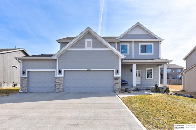 craftsman-style home with a porch, concrete driveway, an attached garage, and a front yard