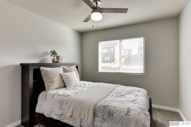 carpeted bedroom with baseboards, a textured ceiling, and ceiling fan