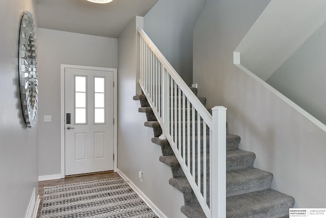 foyer featuring stairway, baseboards, and wood finished floors