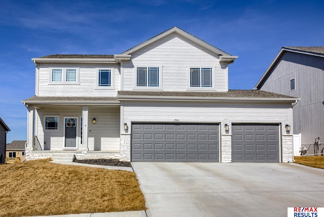 view of front of property with concrete driveway, a front lawn, stone siding, and a shingled roof