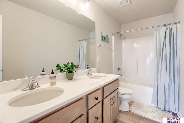 full bath featuring a sink, visible vents, shower / bath combo with shower curtain, and double vanity