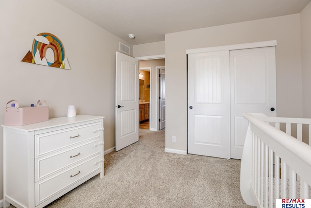 bedroom with baseboards, visible vents, a nursery area, a closet, and light carpet