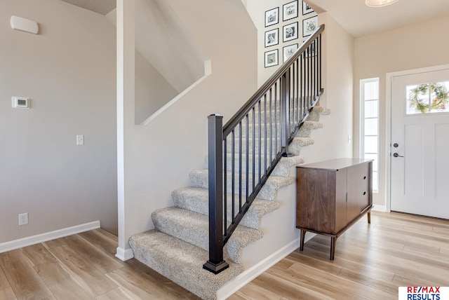 entrance foyer featuring stairs, baseboards, and wood finished floors