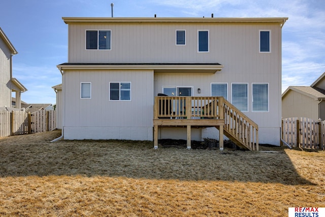 rear view of house with a deck, stairs, and fence