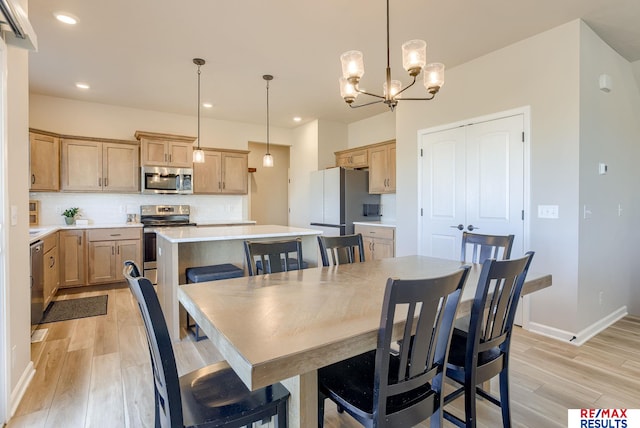 dining room featuring an inviting chandelier, recessed lighting, light wood-style floors, and baseboards