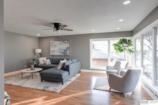 living area featuring recessed lighting, light wood-type flooring, a ceiling fan, and baseboards