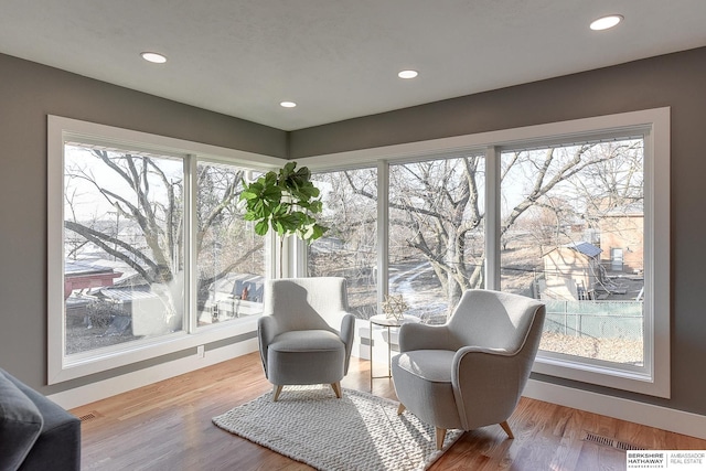 sitting room featuring a healthy amount of sunlight, wood finished floors, and recessed lighting