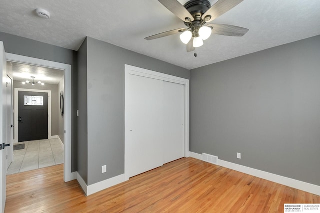 unfurnished bedroom with light wood-style floors, a closet, visible vents, and baseboards