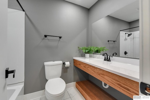 bathroom with marble finish floor, vanity, toilet, and baseboards