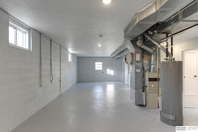 below grade area with concrete block wall, gas water heater, a textured ceiling, and heating unit