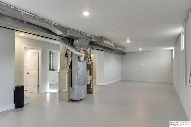 finished below grade area featuring recessed lighting, baseboards, water heater, and heating unit