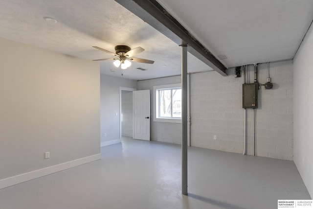 basement featuring concrete block wall, visible vents, ceiling fan, electric panel, and baseboards