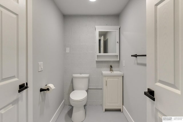 half bathroom with visible vents, vanity, toilet, and baseboards