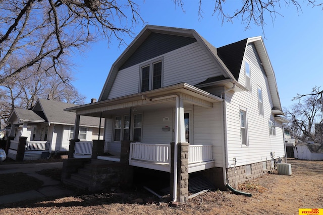 dutch colonial featuring a gambrel roof, roof with shingles, covered porch, and central AC unit