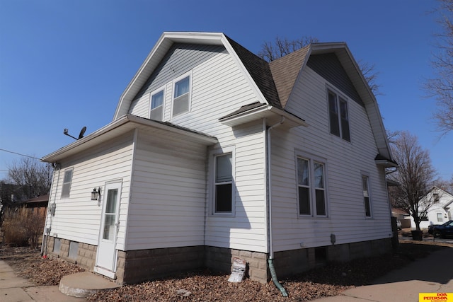 view of property exterior featuring a gambrel roof and a shingled roof