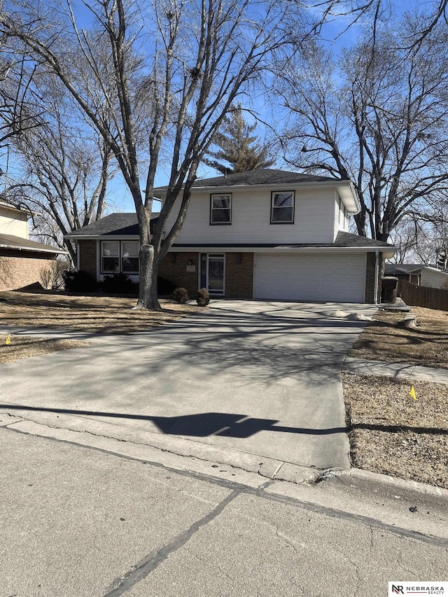 traditional home with driveway, brick siding, and an attached garage