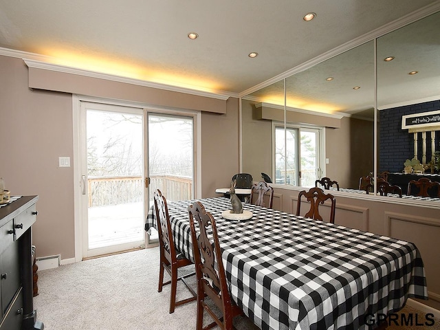 carpeted dining space with recessed lighting, crown molding, and baseboards