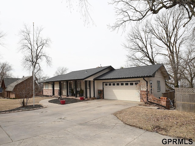 view of front of house featuring driveway, an attached garage, fence, and brick siding