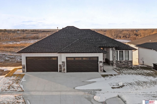 view of front of home with stone siding, roof with shingles, an attached garage, and concrete driveway