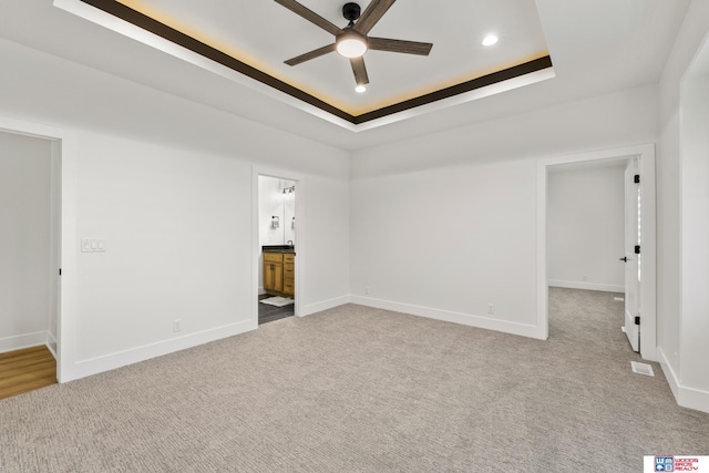 unfurnished room with baseboards, visible vents, ceiling fan, a tray ceiling, and carpet flooring