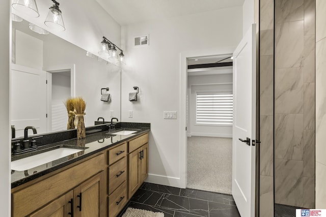 bathroom featuring double vanity, a sink, visible vents, and baseboards