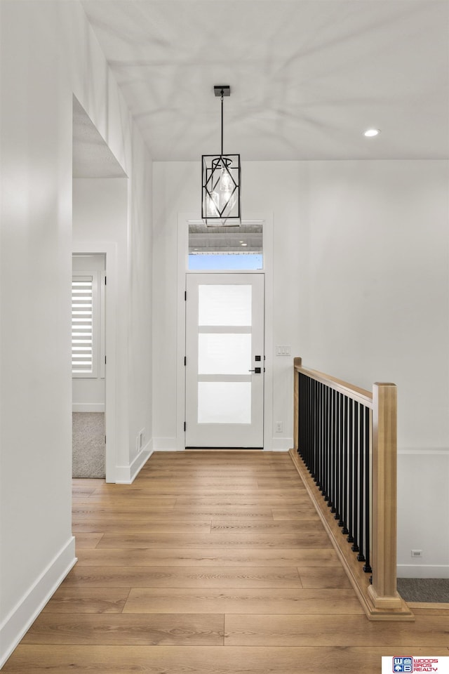 foyer entrance featuring baseboards, wood finished floors, and recessed lighting