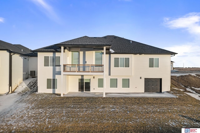 rear view of property with a patio, a shingled roof, central AC, and an attached garage