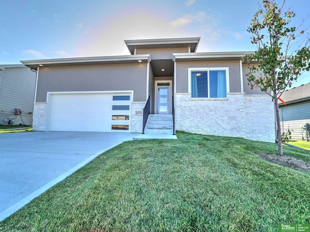 prairie-style home featuring driveway, stone siding, and stucco siding