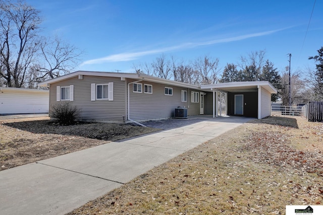 single story home featuring a carport, concrete driveway, central AC, and fence