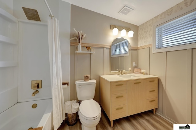 full bathroom featuring toilet, wood finished floors, vanity, visible vents, and wainscoting