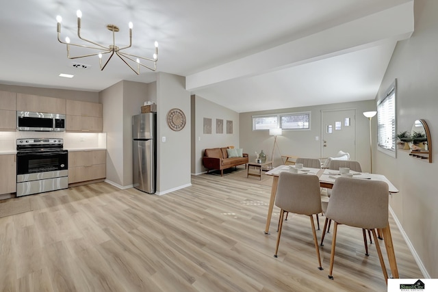 dining room with vaulted ceiling, light wood-type flooring, a chandelier, and baseboards