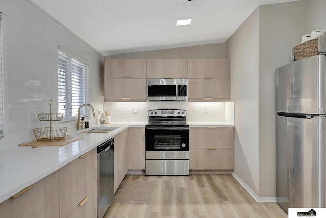 kitchen with light brown cabinetry, appliances with stainless steel finishes, modern cabinets, and a sink