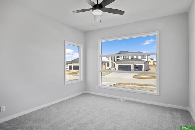 spare room with ceiling fan, carpet floors, and baseboards