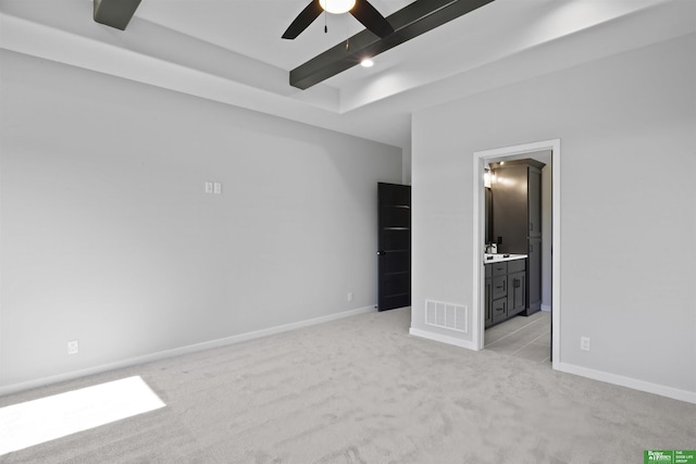 unfurnished bedroom featuring visible vents, beamed ceiling, light carpet, and baseboards