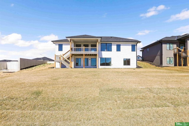 back of property featuring stairway, a lawn, and a balcony