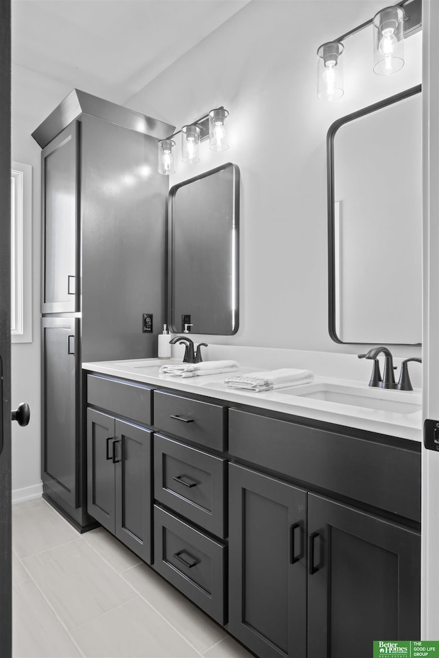 bathroom with tile patterned floors, a sink, and double vanity