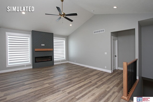 unfurnished living room featuring visible vents, a large fireplace, baseboards, and wood finished floors