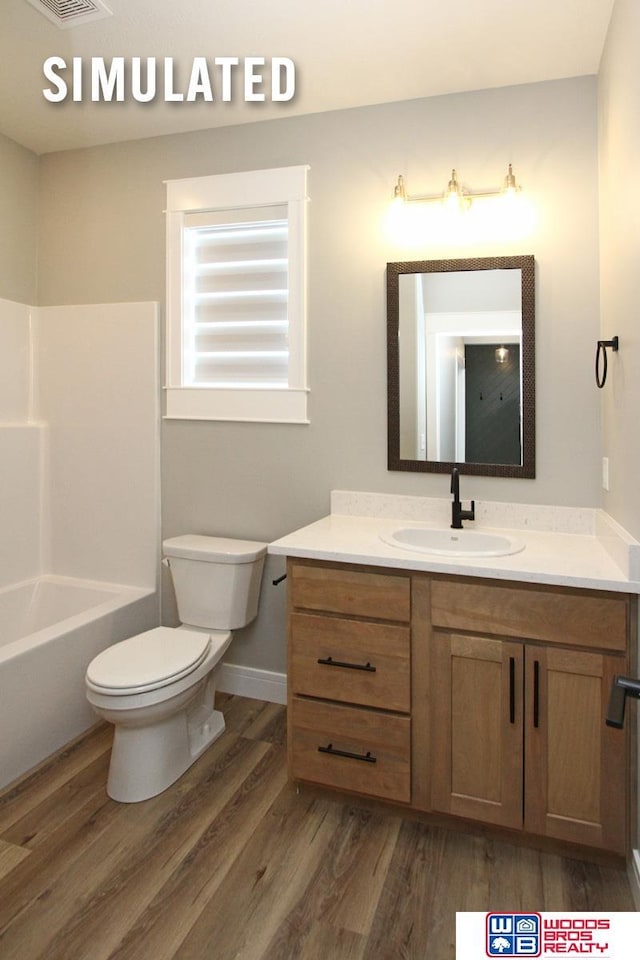 bathroom with visible vents, baseboards, toilet, wood finished floors, and vanity