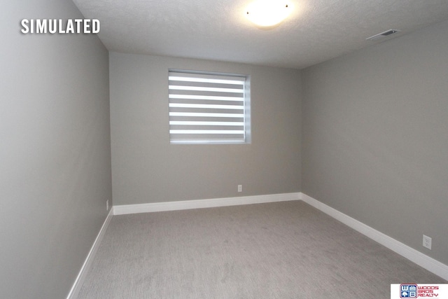 carpeted empty room with baseboards, visible vents, and a textured ceiling