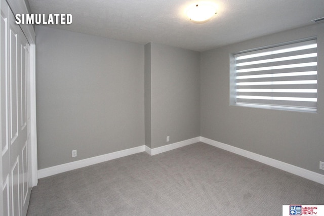 spare room featuring visible vents, baseboards, and carpet flooring