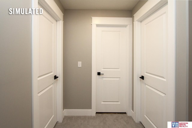 hall featuring light colored carpet and baseboards