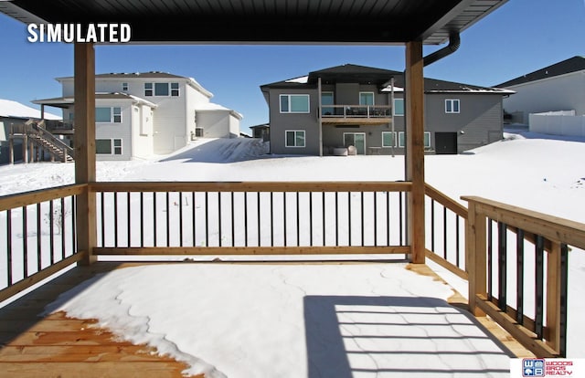 snow covered deck with a residential view