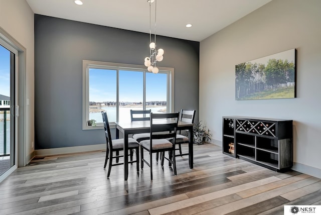 dining space featuring baseboards, recessed lighting, a chandelier, and light wood-style floors