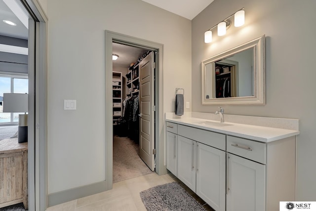 full bathroom featuring a walk in closet and vanity