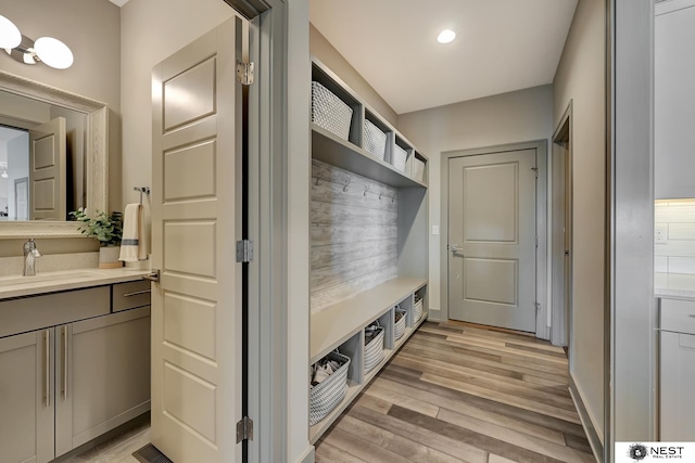 mudroom with a sink, light wood-style flooring, and recessed lighting