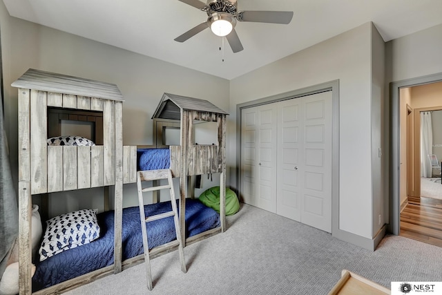 carpeted bedroom featuring a ceiling fan, a closet, and baseboards