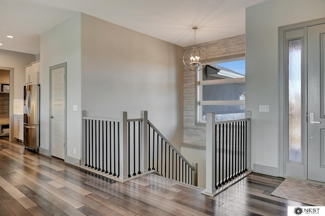 stairway featuring hardwood / wood-style flooring, a chandelier, and recessed lighting