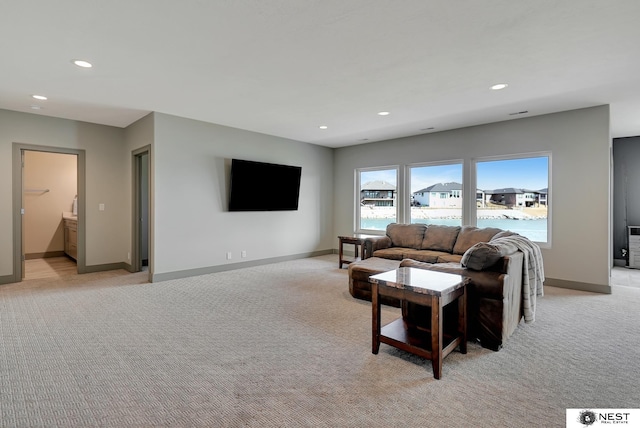 living room featuring recessed lighting, light colored carpet, and baseboards