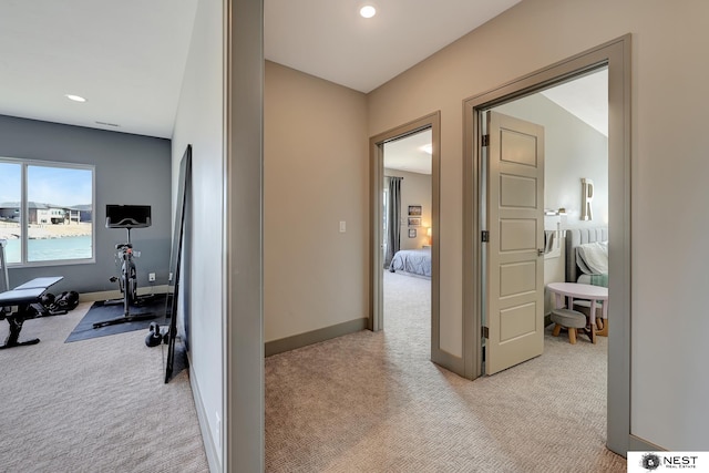 hall featuring light carpet, baseboards, and recessed lighting